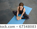 Fitness Woman stretching legs sitting on gym mat. Soirt, and healthy lifestyle. 67348083