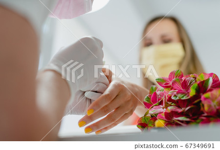 Customer in nail art studio wearing a protective face mask 67349691