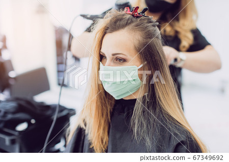 Woman visiting the hairdresser wearing face mask Woman visiting the hairdresser wearing face mask 67349692