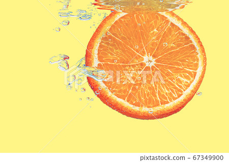 concept of an orange falling into yellow water on a yellow shiny background falls under water with bubbles concept of an orange falling into yellow water on a yellow shiny background falls under water with bubbles 67349900