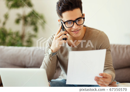 Positive freelancer speaking on smartphone on Positive freelancer speaking on smartphone on 67350570