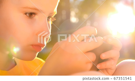 Young gamer playing game on mobile. Kid with smartphone smartphone. Children and Technology. Online game, mobile app background. Technology generation. Happiness and childhood 67351541