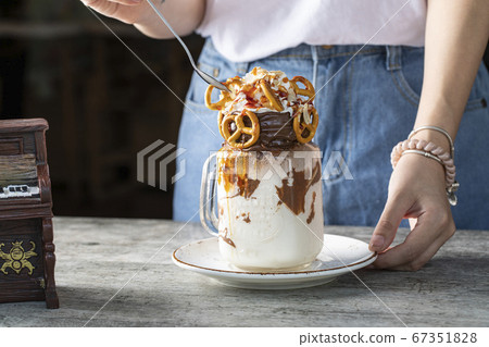 Creamy dessert with chocolate and cookies served by a woman 67351828