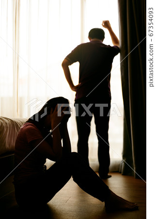 Silhouettes of difficult relationship couple quarreling in dark bedroom at sunset , Stay at home quarantine coronavirus pandemic prevention 67354093