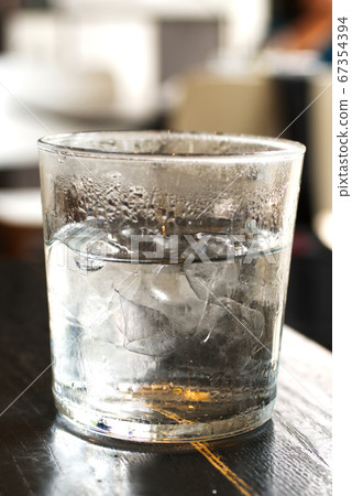 Cold ice water with ice bar in clear glass  67354394