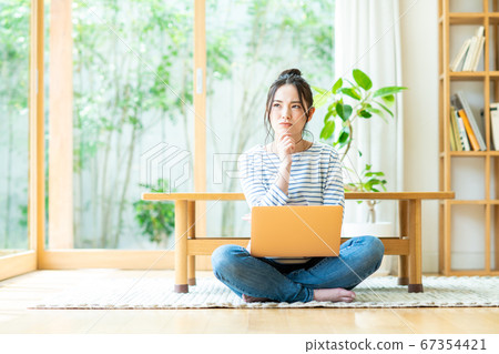 Young woman using a computer in the living room 67354421