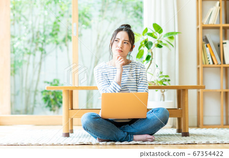 Young woman using a computer in the living room 67354422
