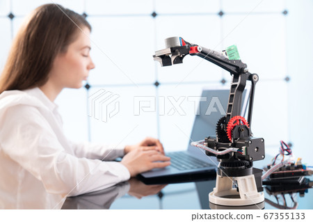 Woman student with robot model arm 67355133