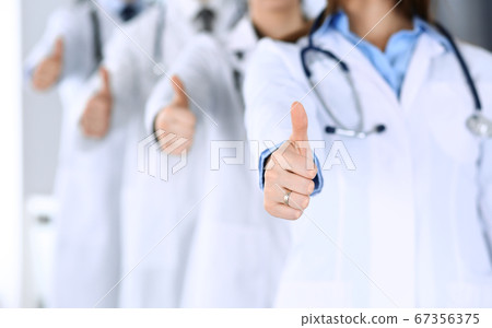 Group of modern doctors standing as a team with thumbs up in hospital office. Physicians ready to examine and help patients. Medical help, insurance in health care, best desease treatment and medicine 67356375