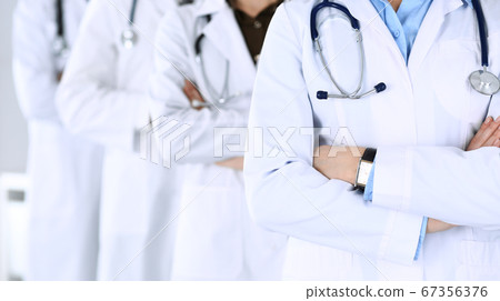 Group of modern doctors standing as a team with arms crossed in hospital office. Physicians ready to examine and help patients. Medical help, insurance in health care, best desease treatment and Group of modern doctors standing as a team with arms crossed in hospital office. Physicians ready to examine and help patients. Medical help, insurance in health care, best desease treatment and 67356376
