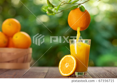 orange juice pouring in glass 67356715