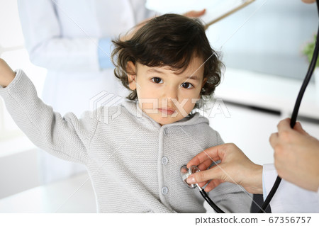 Doctor examining a child patient by stethoscope. Cute arab boy at physician appointment. Medicine and healthcare concept 67356757