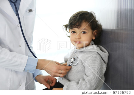 Doctor examining a child patient by stethoscope. Cute arab boy at physician appointment. Medicine and healthcare concept 67356793
