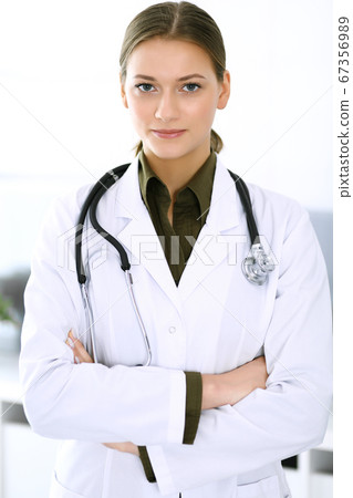 Doctor woman standing straight and looking at camera. Perfect medical service in clinic. Happy future in medicine and healthcare 67356989