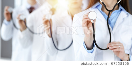 Group of doctors holding stethoscope head, close-up. Physicians ready to examine and help patient in sunny office. Medicine concept Group of doctors holding stethoscope head, close-up. Physicians ready to examine and help patient in sunny office. Medicine concept 67358106