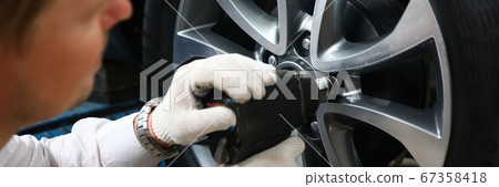 Mechanic using impact wrench Mechanic using impact wrench 67358418