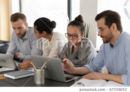Diverse colleagues work on laptops at office meeting 67359052