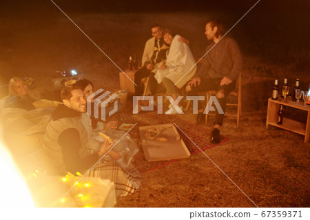 Group of young restful friends having pizza, watching movie and discussing it Group of young restful friends having pizza, watching movie and discussing it 67359371