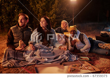 Group of young restful intercultural friends having pizza and watching movie Group of young restful intercultural friends having pizza and watching movie 67359373