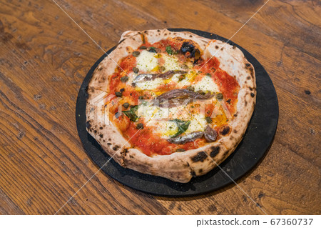 Homemade Naples style pizza with anchovies, olive and mozzarella cheese. Homemade Naples style pizza with anchovies, olive and mozzarella cheese. 67360737