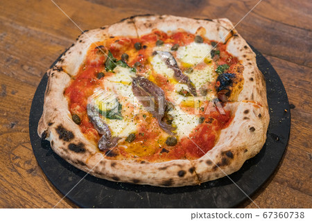Homemade Naples style pizza with anchovies, olive and mozzarella cheese. Homemade Naples style pizza with anchovies, olive and mozzarella cheese. 67360738