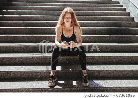 Fit woman with smart phone in the street   67361059