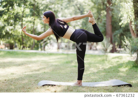 Young fit woman doing morning yoga in the park   67361232