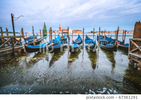 Picturesque view of Gondolas floating in the Grand Canal in evening warm light, San Giorgio Maggiore church in background 67361291