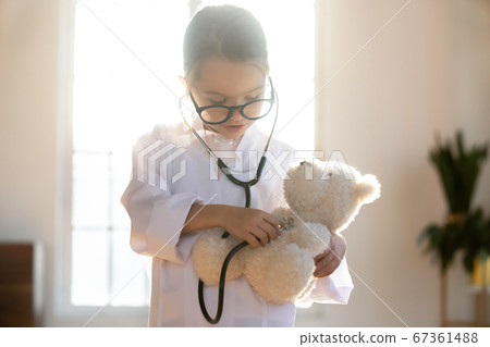 Close up pretty little girl playing doctor, using stethoscope 67361488