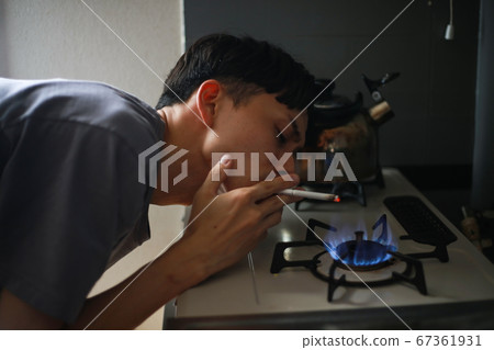 一個用煤氣爐點煙的人 67361931