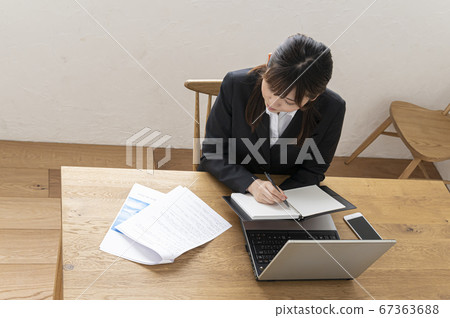 在筆記本在桌子上做筆記的女商人 67363688