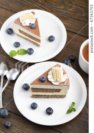 Slice of cheese cake with blueberries on a brown Slice of cheese cake with blueberries on a brown 67363703