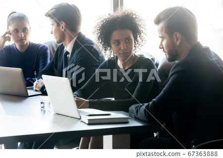 Young diverse business people, working in small groups on projects. 67363888