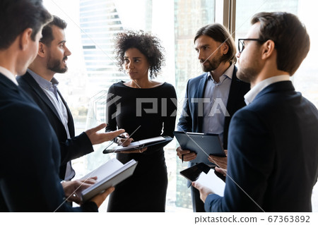 Focused young diverse business people discussing project ideas in circle. 67363892