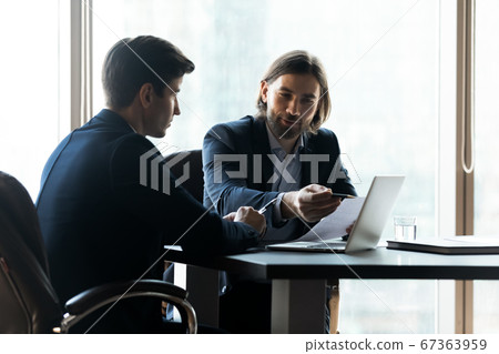 Smiling employees analyzing statistics data at meeting. Smiling employees analyzing statistics data at meeting. 67363959
