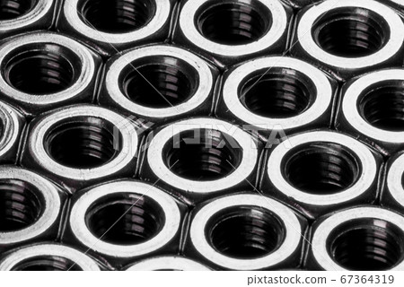 Metal steel nuts laid in composition on a dark 67364319