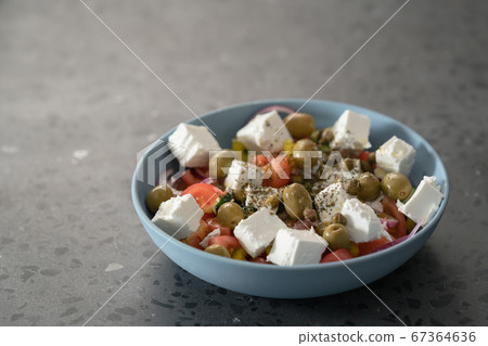Classic greek salad in blue bowl on concrete countertp with copy space Classic greek salad in blue bowl on concrete countertp with copy space 67364636