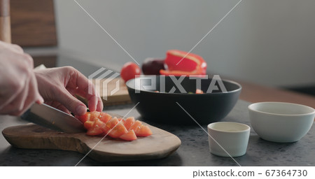 man chop tomatoes on olive wood board man chop tomatoes on olive wood board 67364730