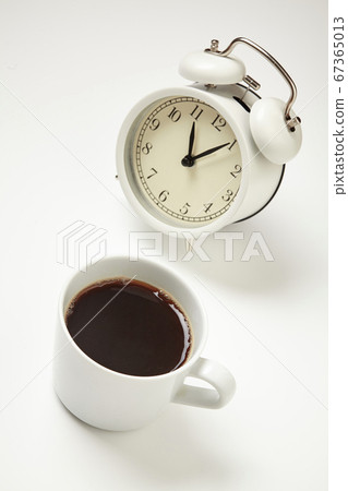 White alarm clock and coffee cup on background. 67365013