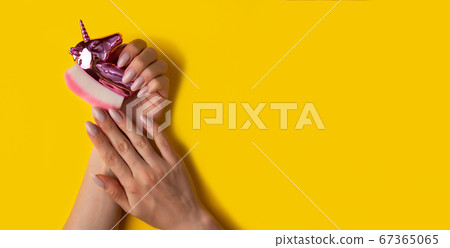 Female hands with a beautiful manicure on a yellow 67365065