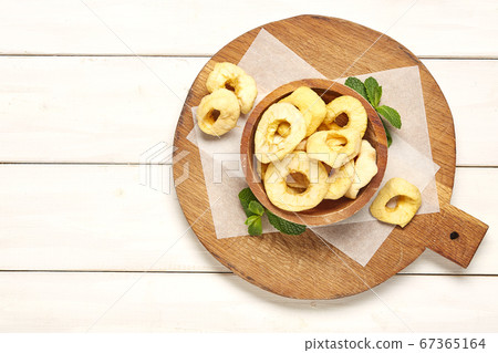 Dried apple on wooden chopping board. Dried apple on wooden chopping board. 67365164