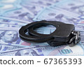 handcuffs against the background of hundred-dollar bills 67365393