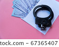 top view handcuffs on an envelope with money, pink background 67365407