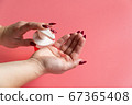 Woman's hand squeezes out liquid soap and dispenser 67365408