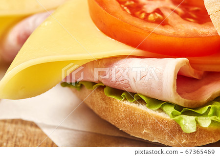 Sandwich baguette on wooden chopping board. 67365469
