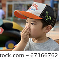 Boy sniffing hands 67366762