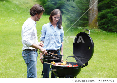 Couple cooking food on barbecue Couple cooking food on barbecue 67366893
