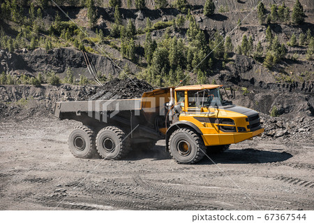 Large quarry dump truck. Loading the rock in dumper. Loading coal into body truck. Production useful minerals. Mining truck mining machinery, to transport coal from open-pit excavator work 67367544