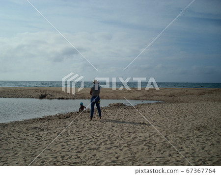 Parents and children playing in the sand on the beach Parents and children playing in the sand on the beach 67367764