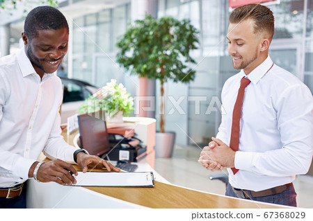 african guy sign a contract in dealership store 67368029